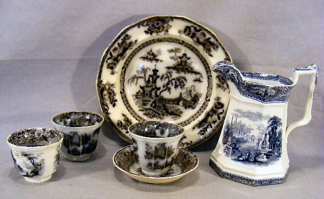 Three mulberry handle less cups and one saucer, 10: Three mulberry handle less cups and one saucer, 10.5" soup bowl with glaze flakes on rim and 8.5" mulberry or dark blue pitcher with hairline on top and bottom edge.