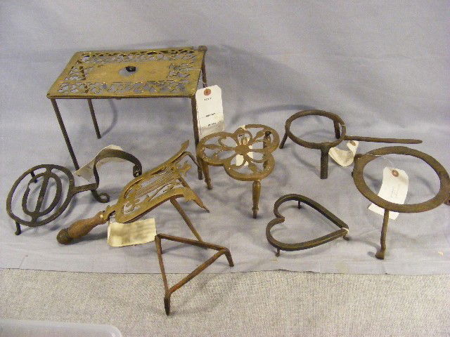 Lot of iron and brass trivets and footman, and br: Lot of iron and brass trivets and footman, and brass and iron fender warmer
