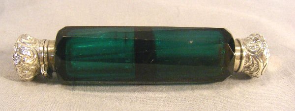 Nineteenth century emerald green cut glass perfume: Nineteenth century emerald green cut glass perfume bottle with silverplated caps and collars, 5" long, one screw cap and one hinged cap, tiny pin point flicks on cut edges.