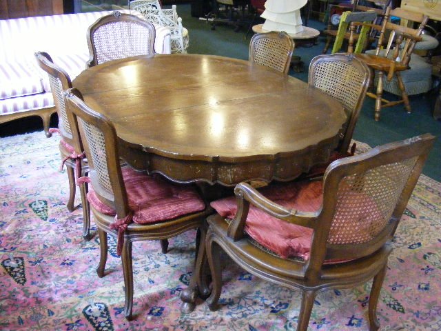 French provincial styled dining room table with si: French provincial styled dining room table with six side chairs and two arm chairs, split base with four leaves, finish damaged on side of table top.