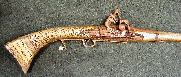 Antique Arabian flintlock rifle, crudely made, bo: Antique Arabian flintlock rifle, crudely made, bone insert on butt stock, sold as is. 62.5" tall, lock is missing screw.