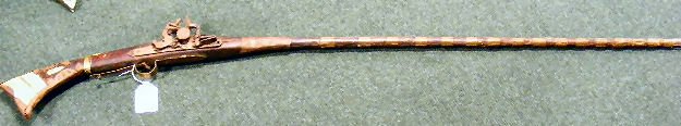 Antique Arabian flintlock rifle, crudely made, bo: Antique Arabian flintlock rifle, crudely made, bone inlaid on stock, sold as is. 62" tall, lock is missing screw.
