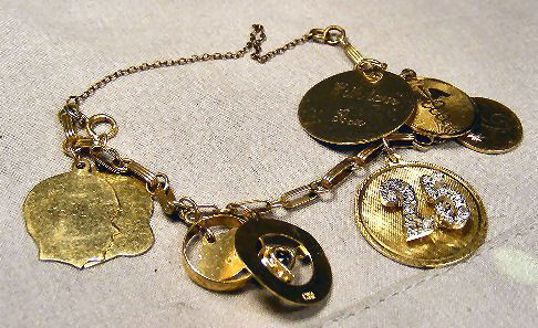 14K gold charm bracelet with charms, 28 grams tota: 14K gold charm bracelet with charms, 28 grams total weight, two charms set with stones