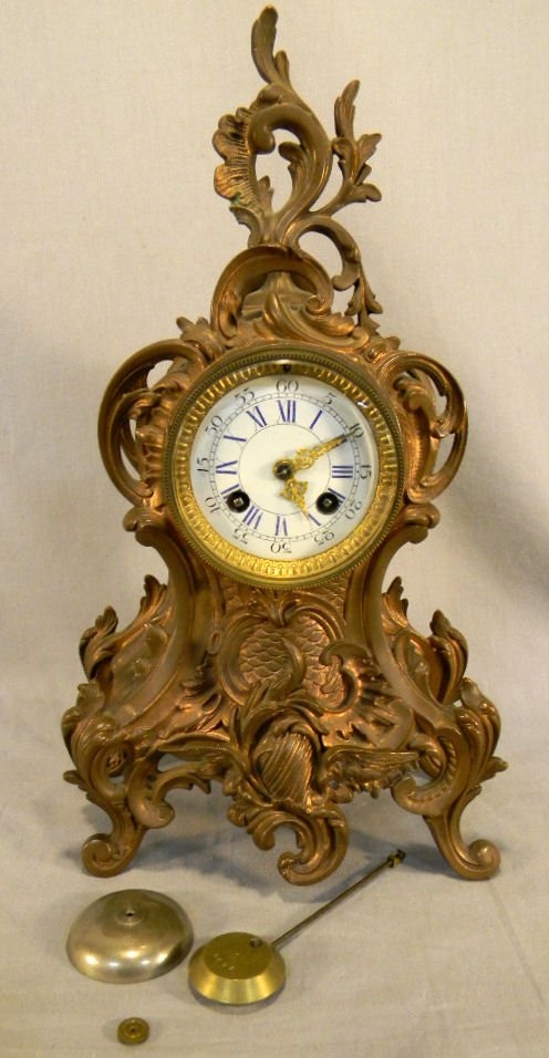 Enzkirch German mantle clock, case is copper: Enzkirch German mantle clock, case is copper or heavy copper plated, enameled dial face, piece broken from finial, clock runs without pendulum (suspension spring broken), 15.75" high - all clocks sold