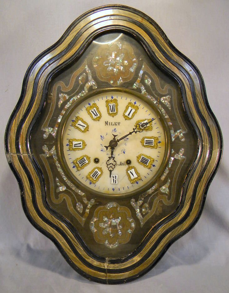 French wall clock marked "Milet", decorated with : French wall clock marked "Milet", decorated with mother of pear, marble dial cracked, 9.75" marble dial face cracked, works frozen, repairs on door, 24" X 19"