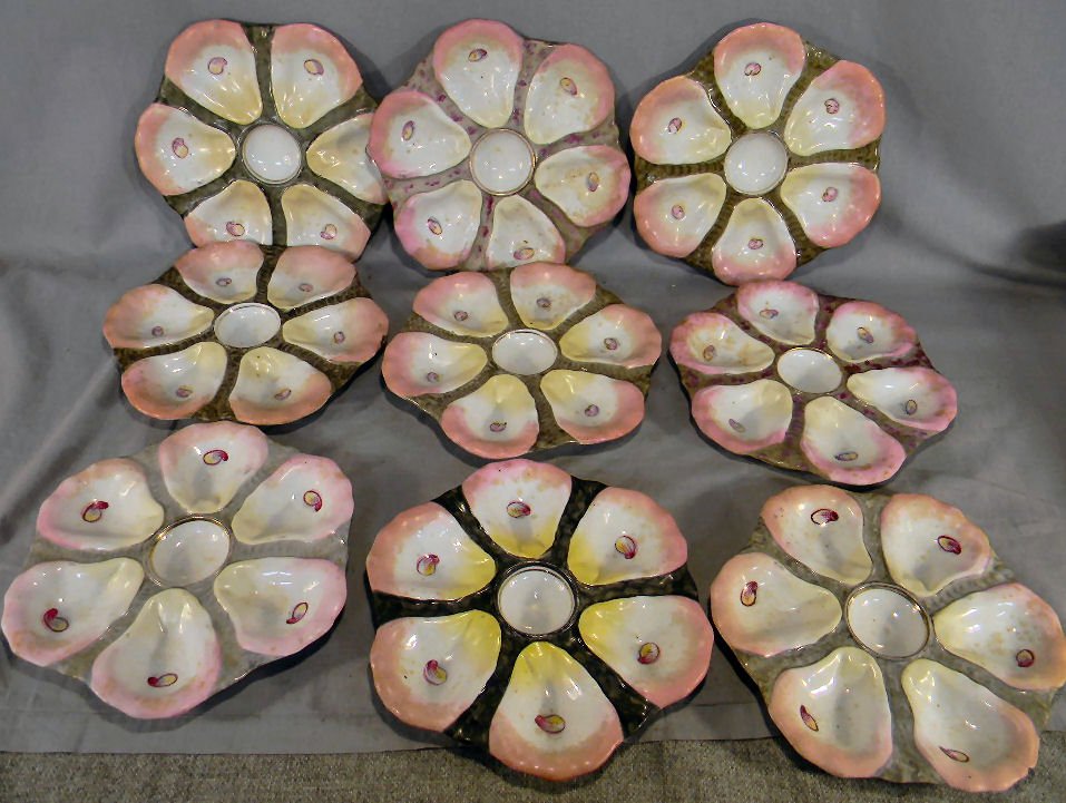 Nine porcelain 9.5" oyster plates: Nine porcelain 9.5" oyster plates, each with impressed numbers, one marked "RW" in blue, one has chip on under edge and one has chip and hairline on edge. Soiled.