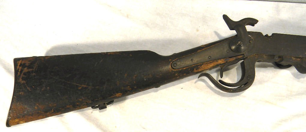 Burnside saddle ring carbine, overall dark pittin: Burnside saddle ring carbine, overall dark pitting, stock is dented, chipped & worn, bolts to hold lock in place broken, markings faint, measures 39in. Overall.