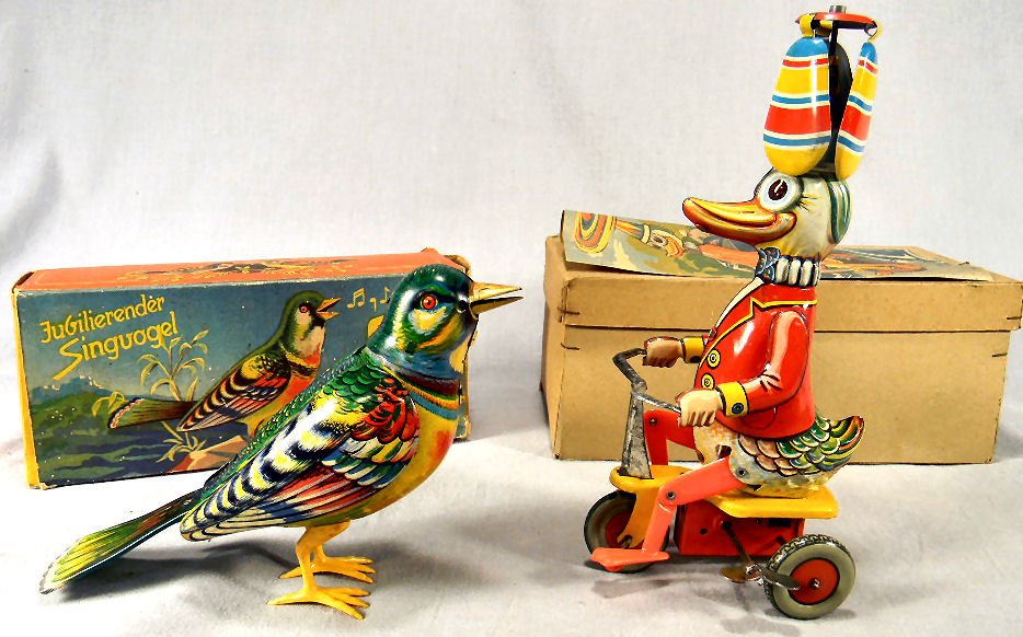 Two West Germany tin wind up toys with boxes, singing: Two West Germany tin wind up toys with boxes, singing bird in working order, wings do not rise completely, no key, together with duck on tricycle in excellent working order. Both in excellent cosmetic