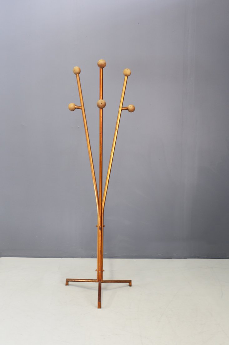 Cova painted steel coat rack, 1936: The coat rack is made with a tubular steel structure painted copper, its peculiarity is in its branch of the arms with spherical elements in wood. Its tripoidal shape of the base is also particular. T