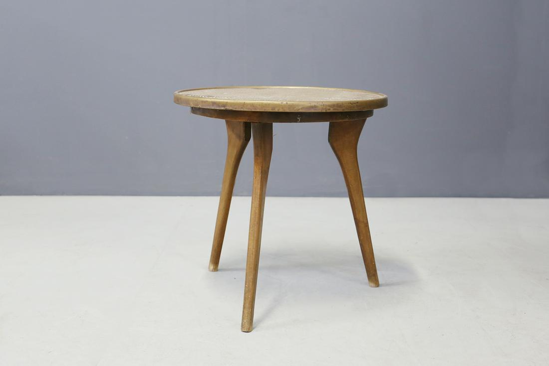 Italian coffee table in copper and wood from 1950s: Elegant Italian coffee table from 1950. The coffee table has a base with three wooden feet. Its round support table is made of tambourised copper. The coffee table is ideal to define living room corne