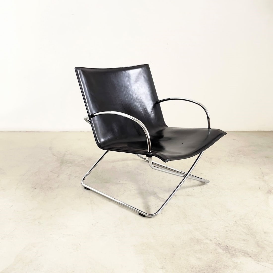 Manifattura Italiana Armchair: Width cm. 75 Height cm. 75 Depth cm. 75 approx. Armchair in steel and black leather. Italian manufacture. 1970s.