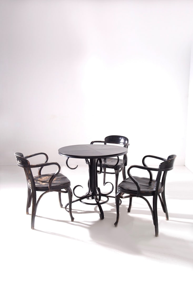Michael Thonet Set of three chairs and table, label present: Height: 80 cm, Width 56.6 cm, Depth: 59 cmSet of three 20s-30s Thonet armchairs in black lacquered wood with their original label under the seat. The coffee table has been restored and is attributed t
