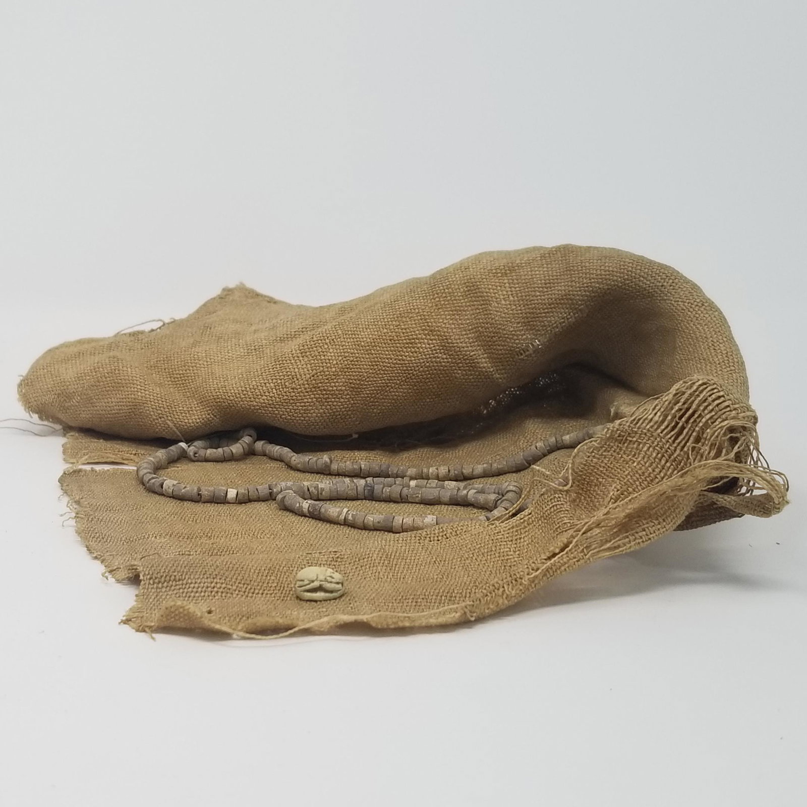 Mummy Linen, Necklace and Scarab: Description: From Ancient Egypt, a decent size piece of authentic mummy linen. Used in the funerary ritual of Late Period Egyptians, 8th-1st Century BCE. The Late Period, 700- 332 BCE, signifies a fin