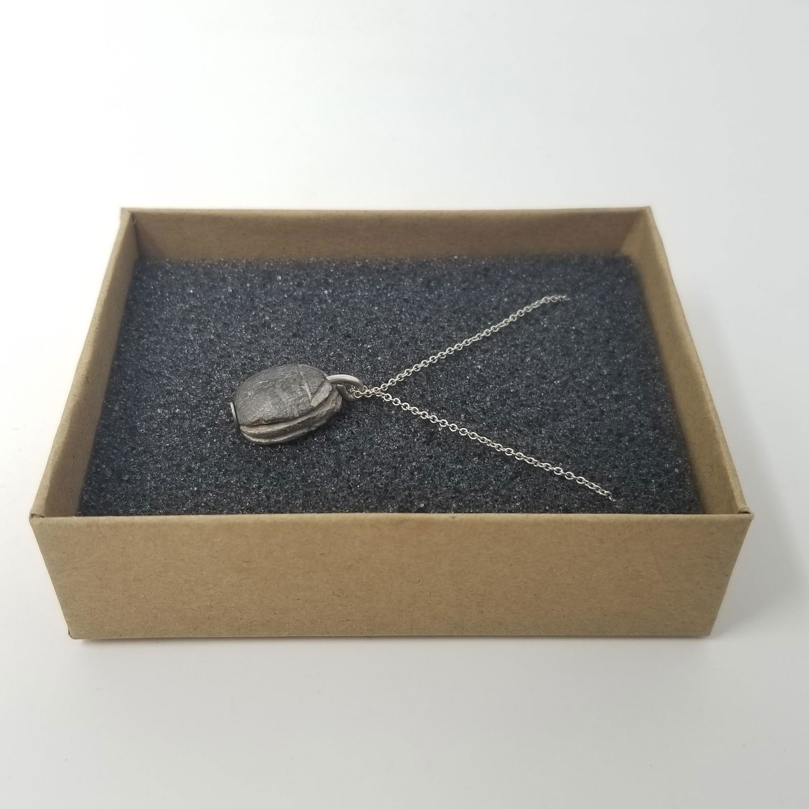 Egyptian Scarab - Necklace: An intact ancient Egyptian scarab with hieroglyphs depicting a beetle, rare black colour. 17th Dynasty to Late Period. These were used as amulets and seals, often being buried with mummies. The scarab