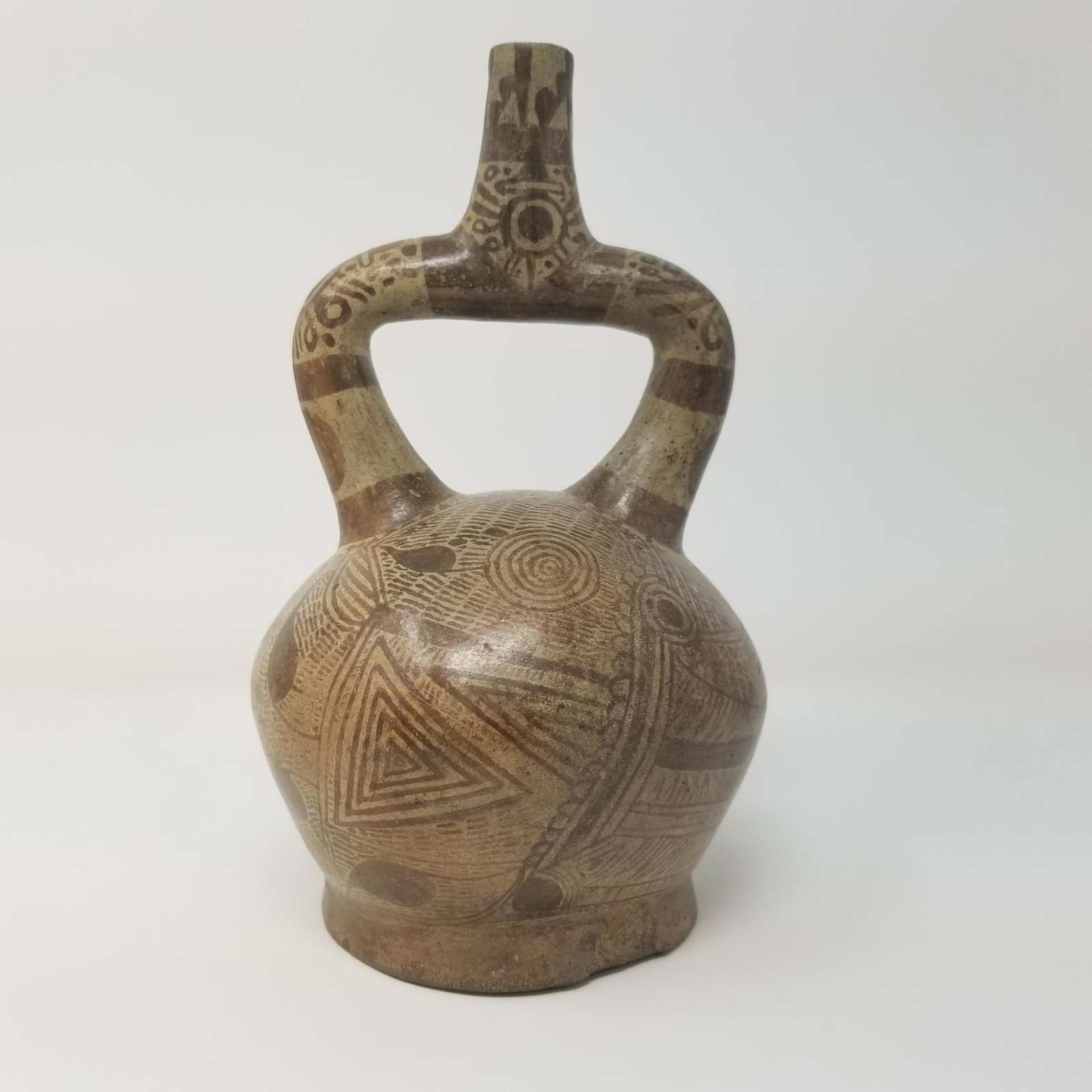 Fineline - Pre-Columbian Stirrup - 650 CE: Description: From the ancient peoples of Peru, a fabulous expression of art using the fineline technique, depicting warriors weapons and the starry heavens. Dates to Moche IV Phase, 650 CE. 8" tall. 