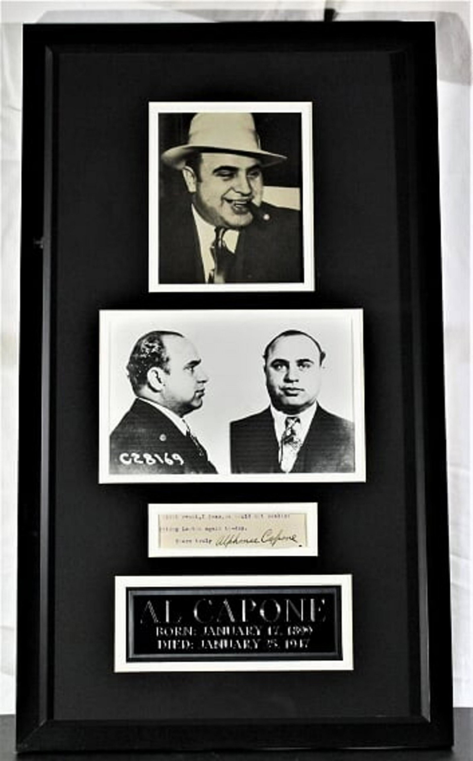 Al Capone signature, Framed: Al Capone (1899-1947), 1” x 4” Clipped signature. Partial letter is included from the excized signature. Matted and framed with two black and white images of Al Capone with an overall size