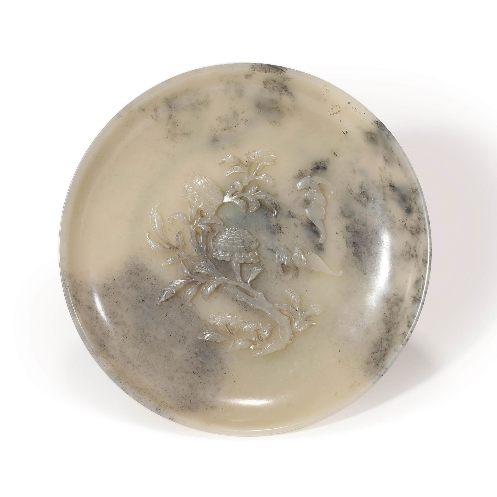 A Black and Grey Jade Round Washer: Dimensions: Height: 3.5cm, Diam.20.9cm A Black and Grey Jade Round Washer. Raised on a short foot ring to a flared sides, decorated to the central in relief with motif. The stone of buff tone with som