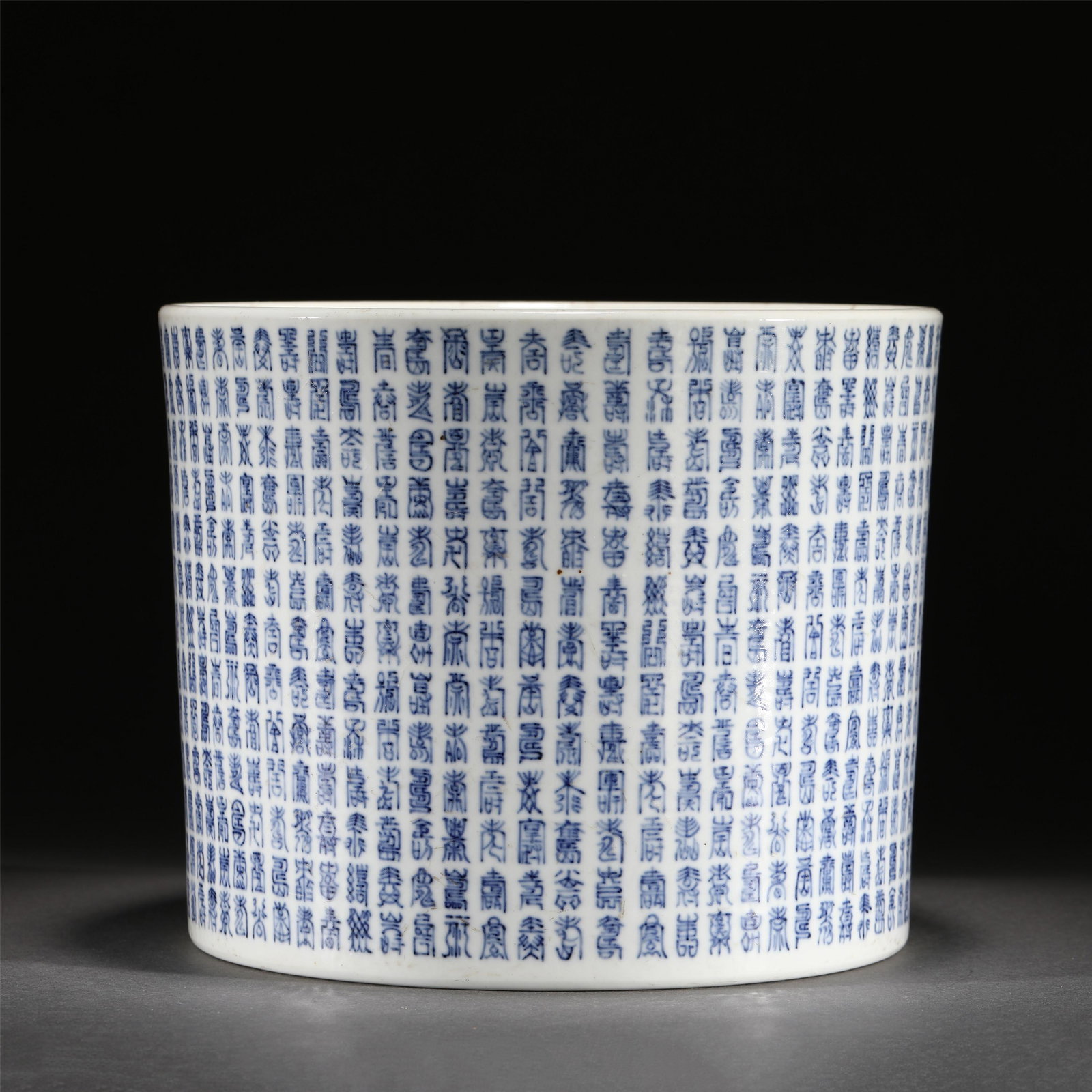 A BLUE AND WHITE PORCELAIN BRUSH POT/QING DYNASTY: A BLUE AND WHITE PORCELAIN BRUSH POT/QING DYNASTY 24.6 cm L x 20 cm H Of cylindrical form, painted on the exterior with the Chinese auspicious characters.