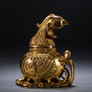 A CHINESE GILT BRONZE PHOENIX HEAD POT: A CHINESE GILT BRONZE PHOENIX HEAD POT 9.8 cm L x 5 cm W x 10.2 cm H x Weight 430 gram. The vessel cast as a seated phoenix, the wings upswept on either side to flank under cover, its pierced