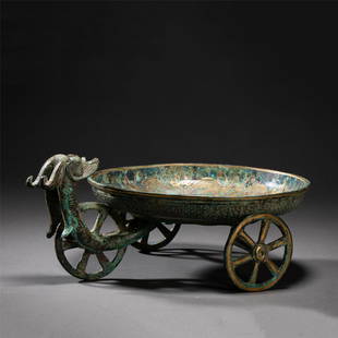 A CHINESE BRONZE DISH: A CHINESE BRONZE DISH 29 cm L x 11 cm W x 13 cm H x Weight 1740 gram. Of circular shaped vessel supports on three wheels supports, decorated with archaic pattern at the surface, the mottled