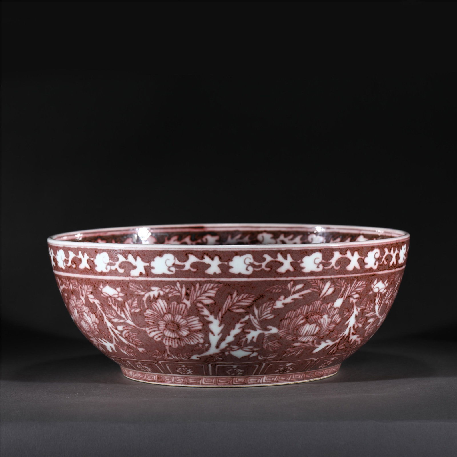 A RED UNDER GLAZE PORCELAIN BOWL,MING: A RED UNDER GLAZE PORCELAIN BOWL,MING 40.7 cm Diam x 16 cm H x Weight 5440 gram. The deep rounded sides rising from a slightly tapered foot to a rim, the exterior painted peony spray in copper red, al