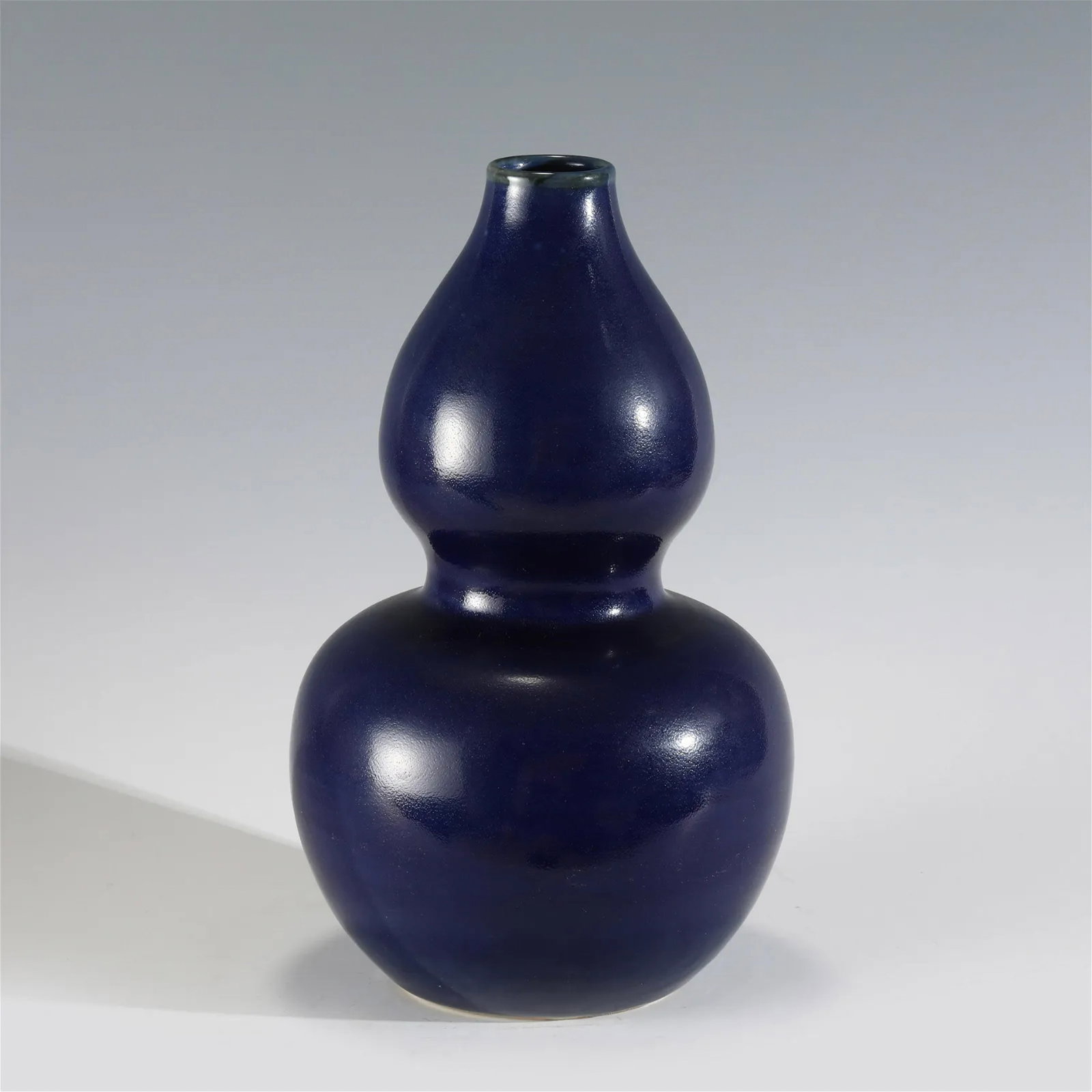 MING JI BLUE GOURD BOTTLE: Measurements: Height: 30.8 cm, Diam: 18.7cm Chinese Ming Dynasty Ji Blue Porcelain Gourd Bottle Vase. The porcelain potted in a shape of double gourd bottle vase, with two bulbous bellies conjoined to