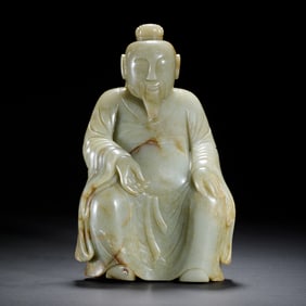 A CARVED JADE SEATED FIGURE