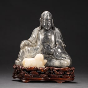 A CHINESE CARVED JADE SEATED FIGURE OF ARHAT