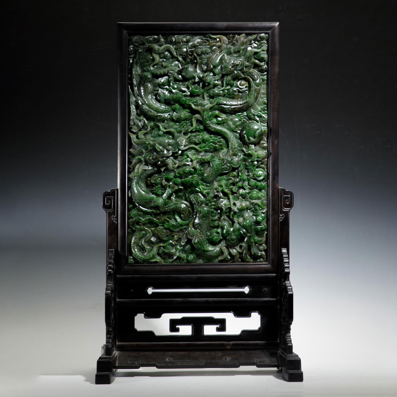 CHINESE ZITAN JASPER DRAGON SCREEN: Dimensions: L. 36.4 cm. W. 19.3 cm. H. 63.7 cm. Weight 8045 grams. This magnificent table screen features a dense, high-relief carving of dragons in Hetian spinach jade, set within a finely crafted zi