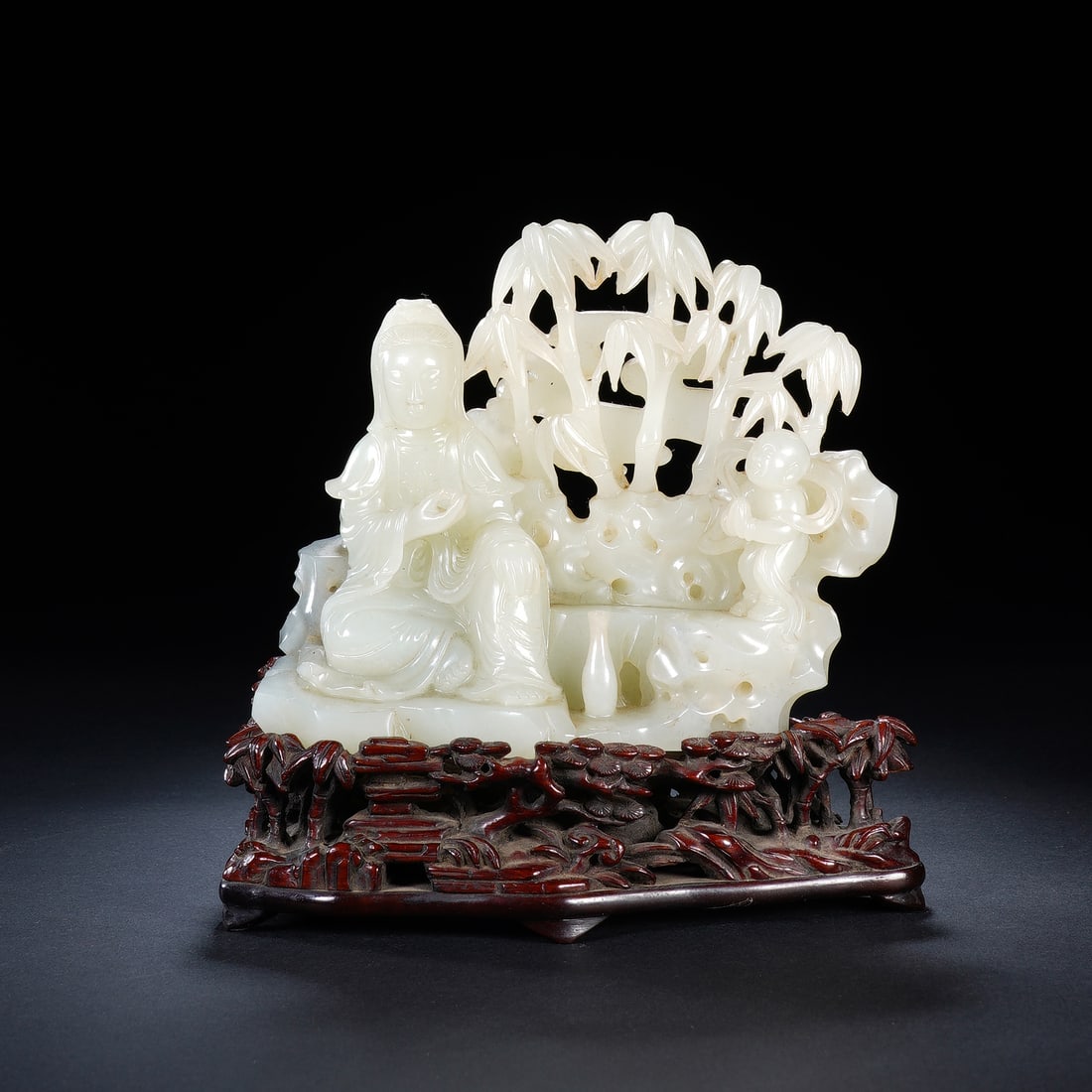 CHINESE WHITE JADE GUANYIN STATUE: Dimensions: 14x8x14.5 cm. Weight 632 grams. This Chinese white jade carving depicts Guanyin seated amid openwork bamboo with a child figure, measuring 14 cm in length, 8 cm in width, 14.5 cm in height