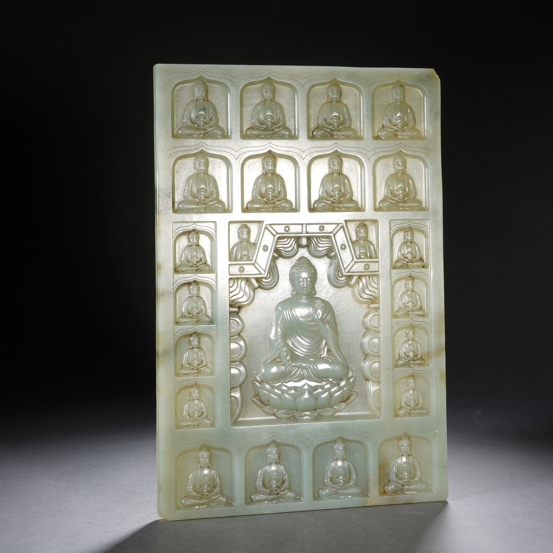 CHINESE WHITE JADE BUDDHA PLAQUE: Dimensions: 16.5x24.5x0.7 cm. Weight 679 grams. This exquisite Chinese white jade plaque is intricately carved with a central seated Sakyamuni Buddha on a lotus throne, flanked by rows of smaller budd
