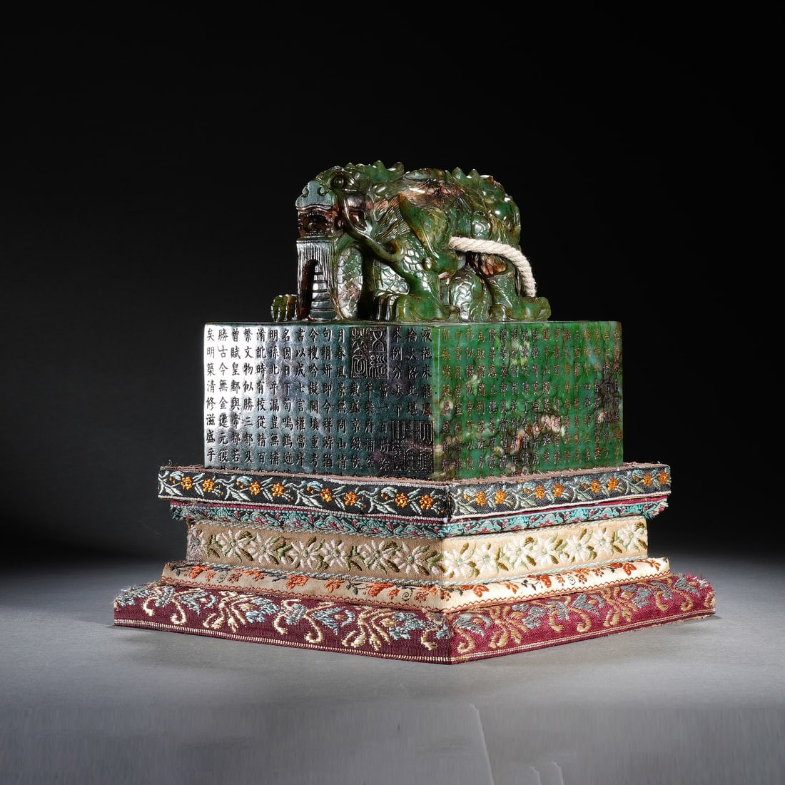 CHINESE SPINACH JADE DRAGON SEAL: Dimensions: 13x13x14 cm. Weight 4800 grams. This monumental Chinese spinach jade seal is crowned with a dynamically carved interlocking dragon finial, its sinuous bodies and scaled details rendered wi