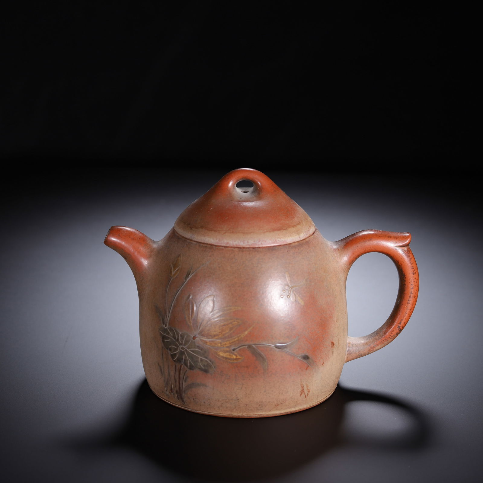 CHINESE YIXING ZISHA LOTUS TEAPOT: Dimensions: L. 15 cm. W. 10 cm. H. 11 cm. Weight 370 grams. This elegant Chinese Yixing zisha clay teapot features a classic Qinquan form with a domed lid and loop handle, decorated with relief-carved