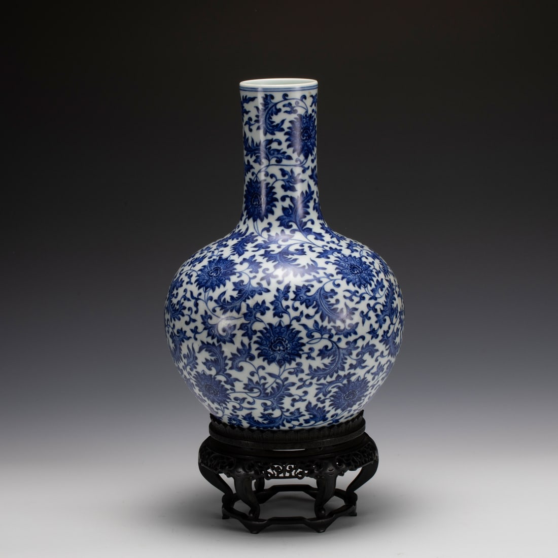 BLUE & WHITE LOTUS CELESTIAL VASE: Measurements: Width: 21.5 cm, Height: 31.3 cm Chinese Blue and White Lotus Porcelain Celestial vase On Carved Hardwood Stand. Potted in celestial shape vase, thick and tall, globular lower body,