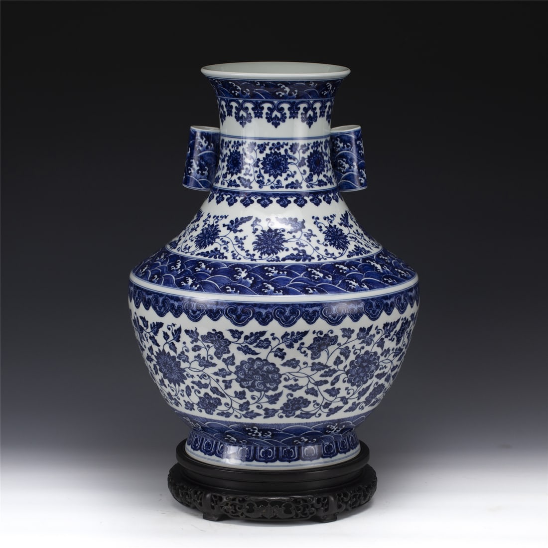 QING QIANLONG BLUE & WHITE DOUBLE EAR ZUN: Dimensions: Width: 39.4 cm, Height: 52 cm Chinese Qing Dynasty Qianlong Blue and White Porcelain Double Ear Zun On Carved Hardwood Stand. Potted in a Zun shaped vase, thick and large, a drum