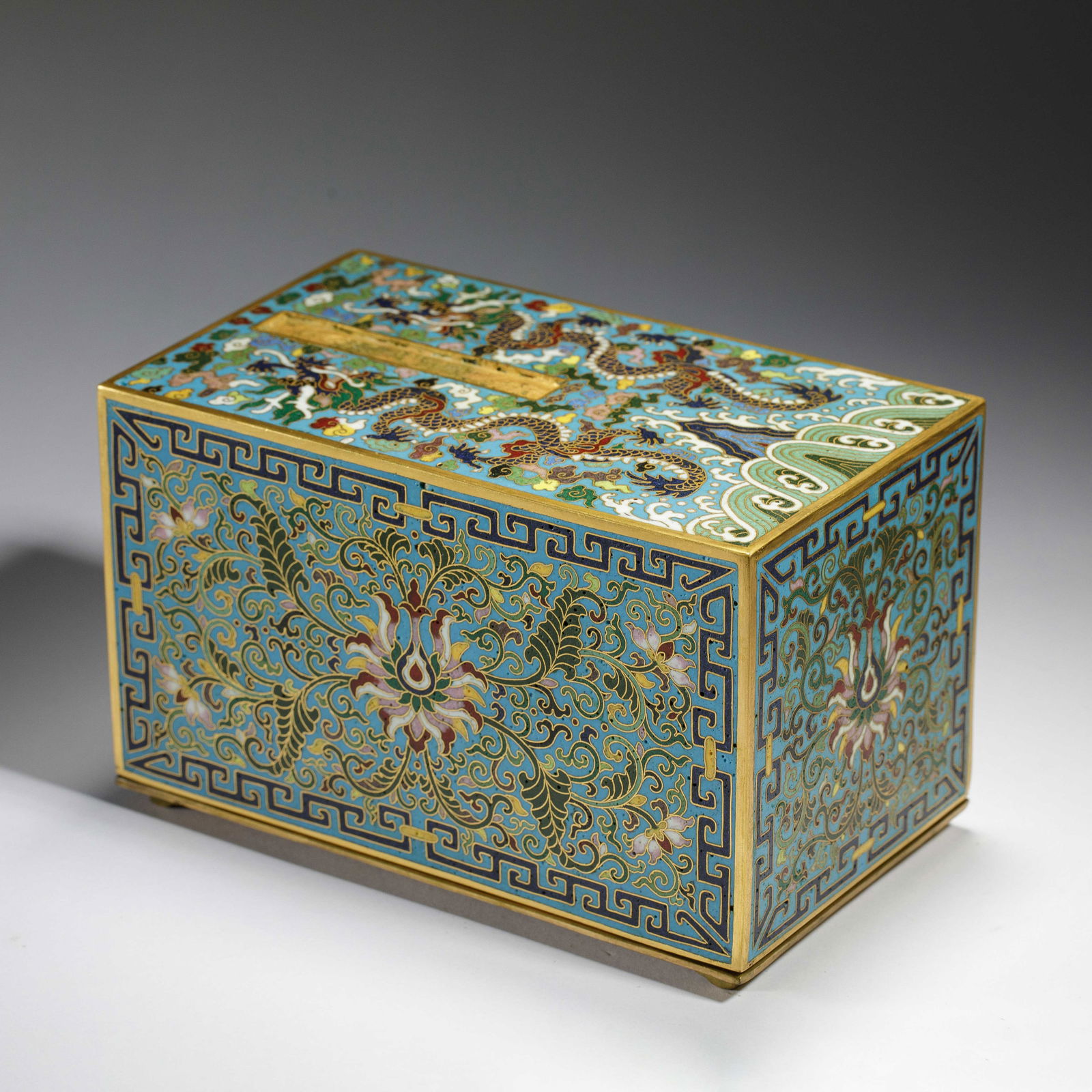 CHINESE CLOISONN? DRAGON & FLOWER BOX: Dimensions: L. 17.2 cm. W. 10.2 cm. H. 10.6 cm. Weight 1745 grams. This exquisite rectangular box is crafted in cloisonn? enamel, featuring a bright sky-blue ground adorned with intricate wirework of