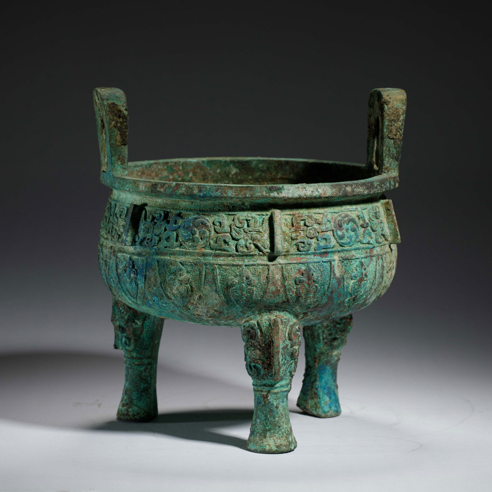 CHINESE BRONZE TRIPOD CENSER: Dimensions: L. 21.3 cm. H. 23.6 cm. Weight 2800 grams. This Chinese bronze tripod censer features a classic two-handled, three-legged form, measuring 21.3 cm in length, 23.6 cm in height, and