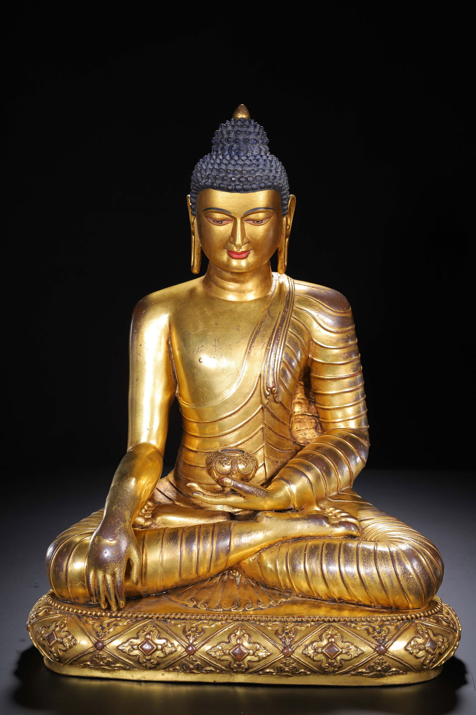 CHINESE GILT BRONZE BUDDHA STATUE: Dimensions: L. 30 cm. W. 22 cm. H. 39 cm. Weight 7320 grams. This serene Chinese gilt bronze statue depicts Sakyamuni Buddha in the lotus position, with the right hand in the earth-touching mudra