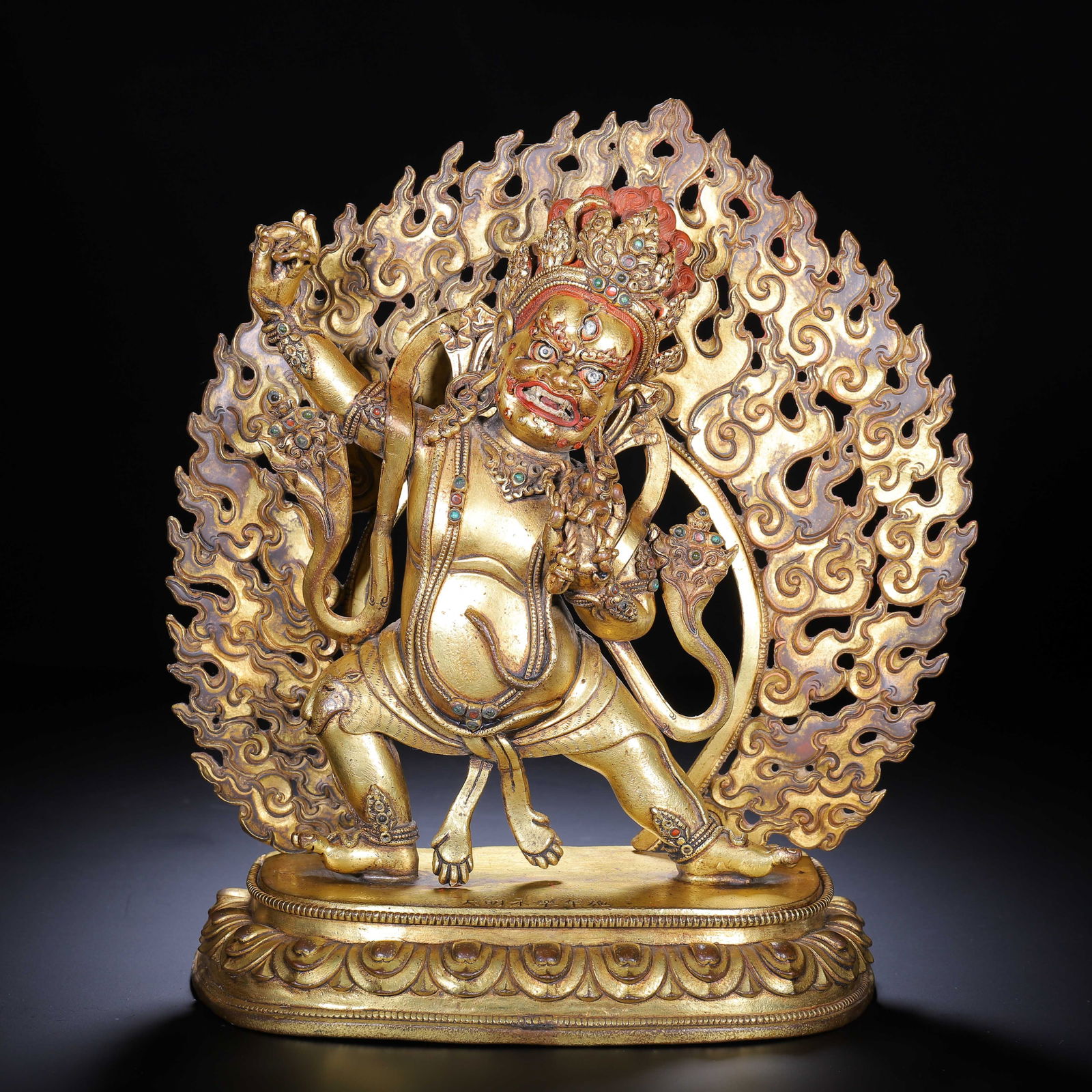 CHINESE GILT BRONZE BUDDHIST DEITY STATUE: Dimensions: L. 22 cm. W. 8 cm. H. 24 cm. Weight 3090 grams. This dynamic Chinese gilt bronze statue depicts a wrathful Buddhist guardian deity, rendered with bulging eyes, bared fangs, and a