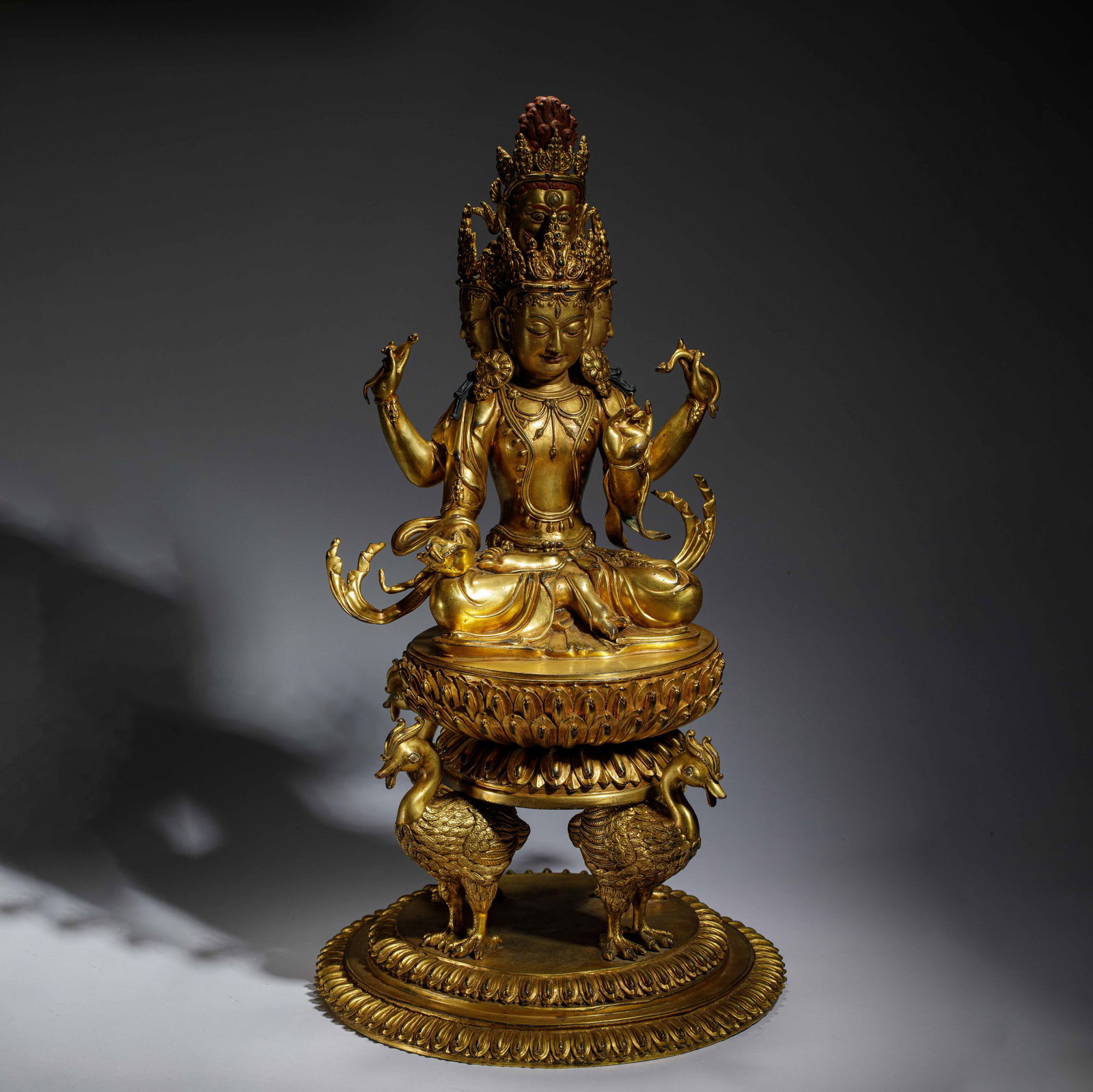 CHINESE GILT BRONZE FOUR-ARM BUDDHA MOTHER: Dimensions: L. 30 cm. H. 56.8 cm. Weight 15830 grams. This magnificent gilt bronze sculpture depicts the four-arm Buddha Mother seated in lotus pose on a double-tiered lotus base supported by