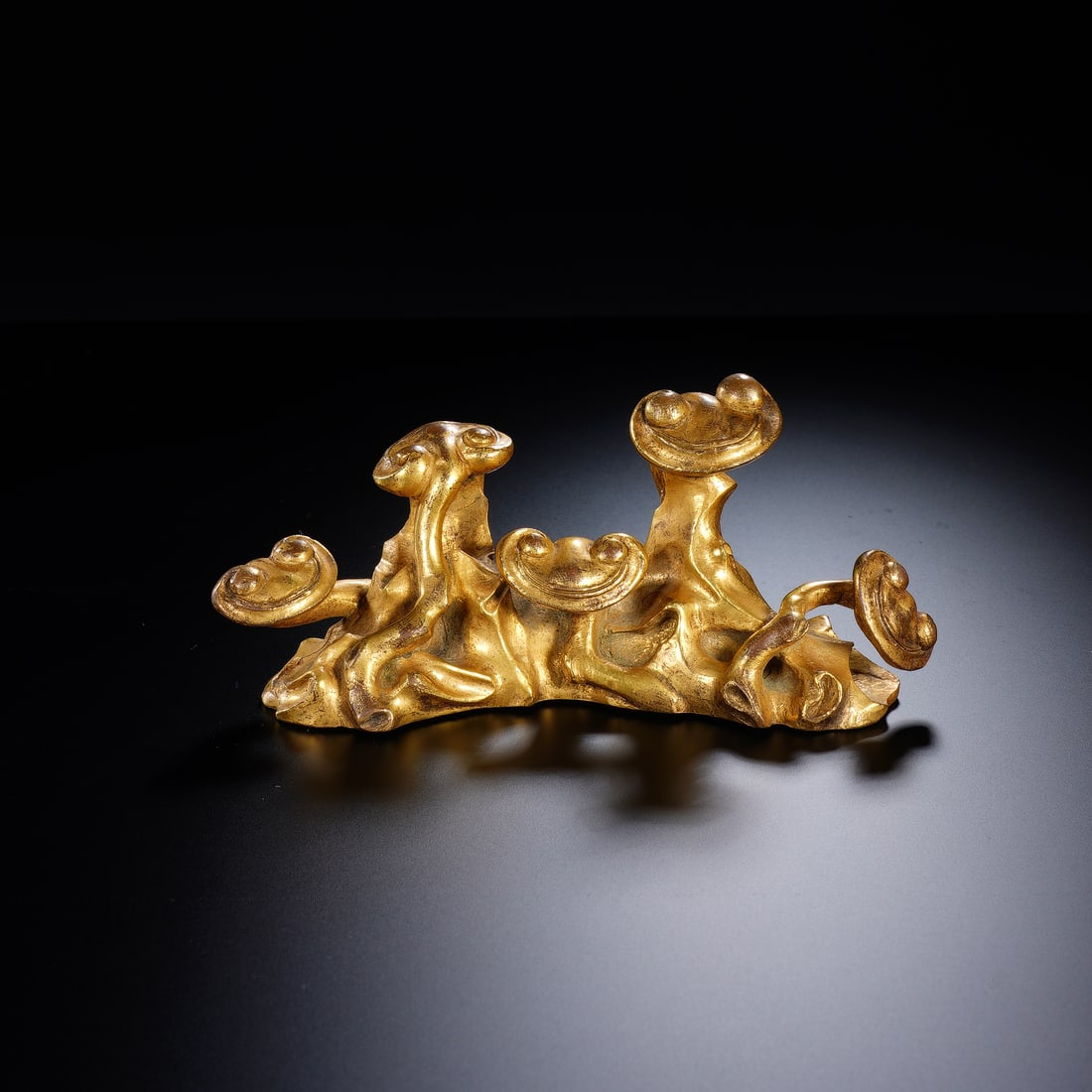 CHINESE GILT BRONZE GANODERMA BRUSH REST: Dimensions: 13.5x4.5x6 cm. Weight 548 grams. This Chinese gilt bronze brush rest is modeled as gnarled ganoderma fungi with naturalistic, twisting forms, measuring 13.5 cm in length, 4.5 cm in