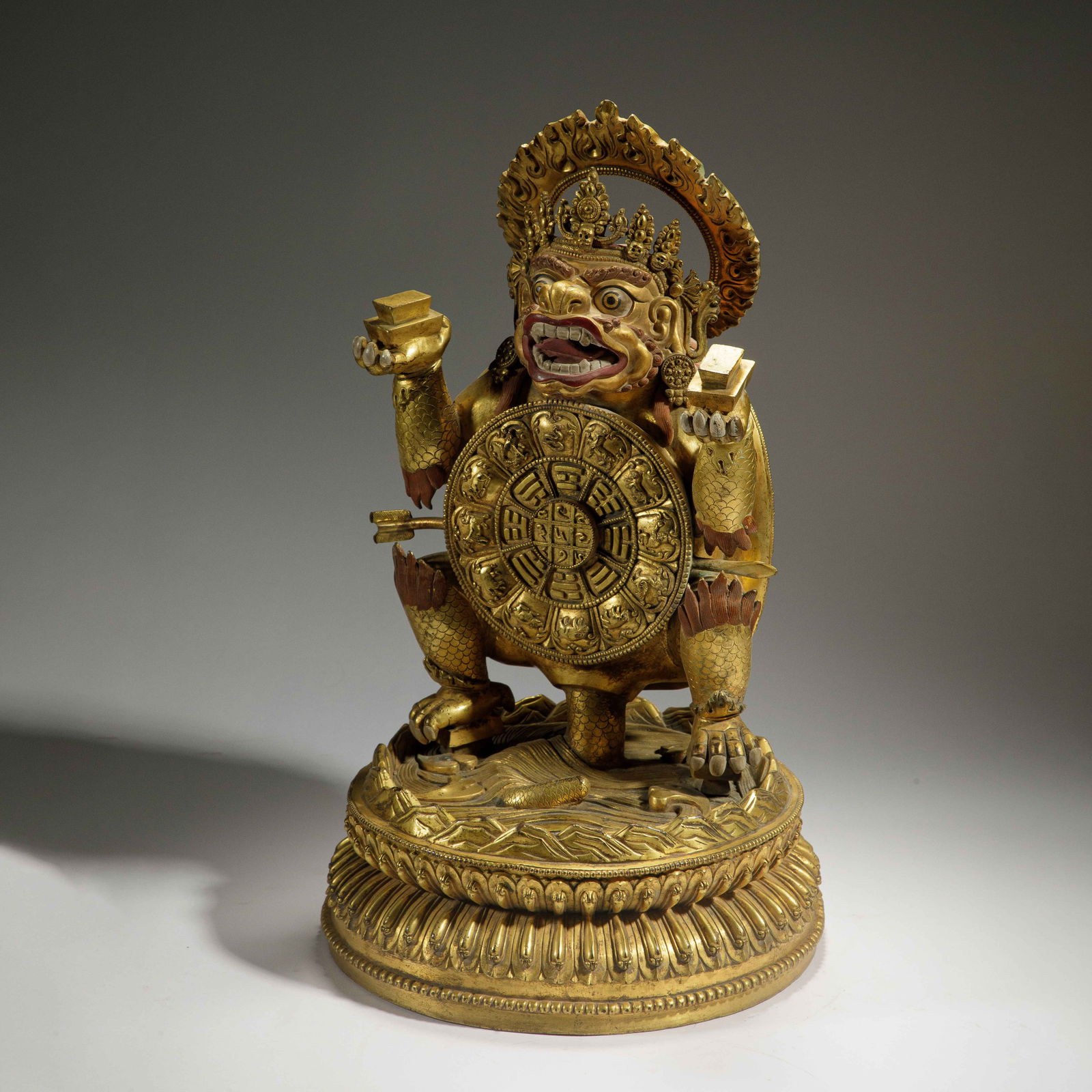 CHINESE GILT BRONZE SAMSARA VAJRA PROTECTOR: Dimensions: L. 21 cm. H. 41 cm. Weight 9740 grams. This powerful sculpture of the Samsara Vajra protector is cast in bronze and richly gilded, depicting the deity with a fierce expression, holding rit