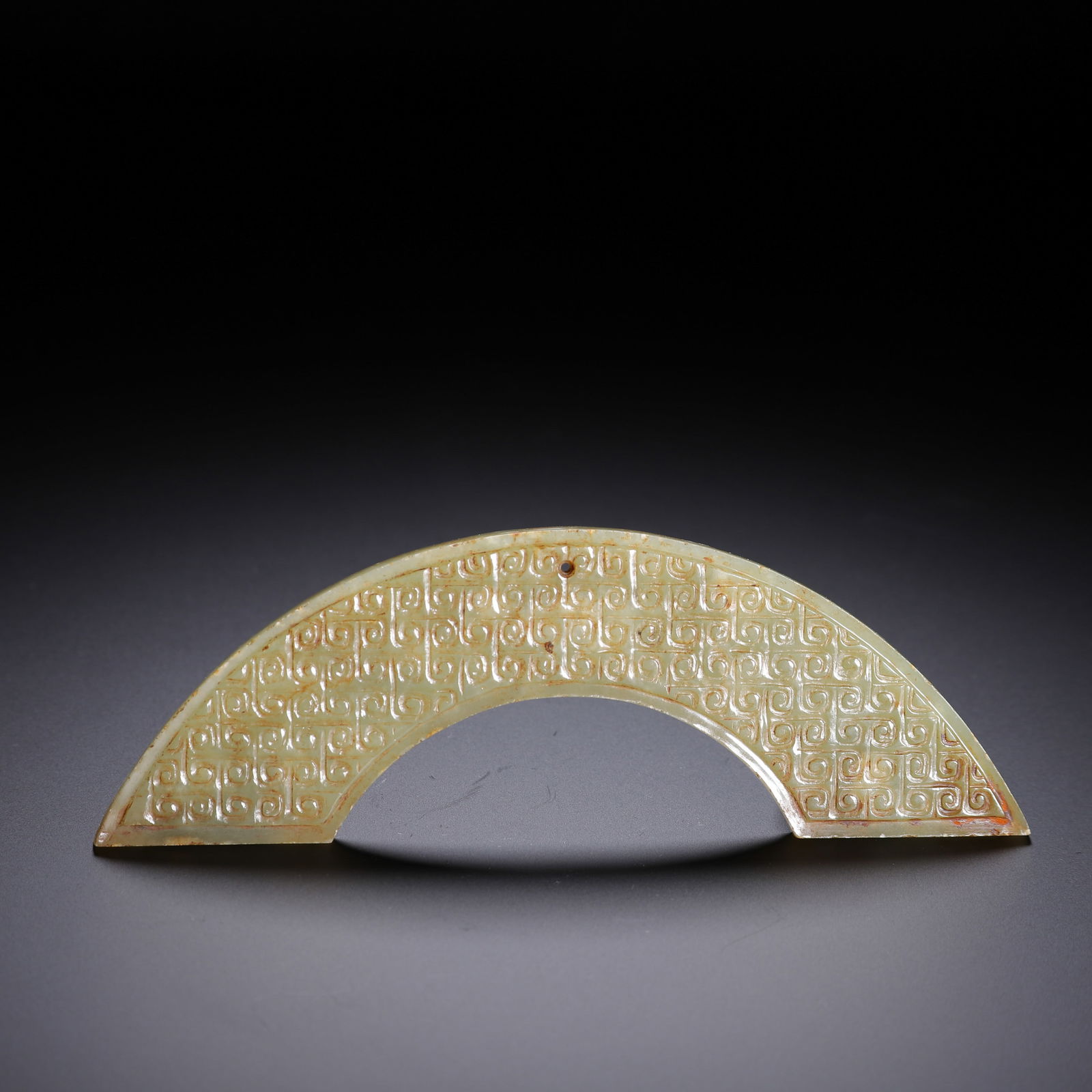 CHINESE ARCHAIC JADE HUANG PENDANT: Dimensions: L. 14 cm. W. 4.5 cm. Weight 50 grams. This refined Chinese archaic jade huang (crescent pendant) is carved in a semi-circular form with a dense pattern of leiwen (interlocking