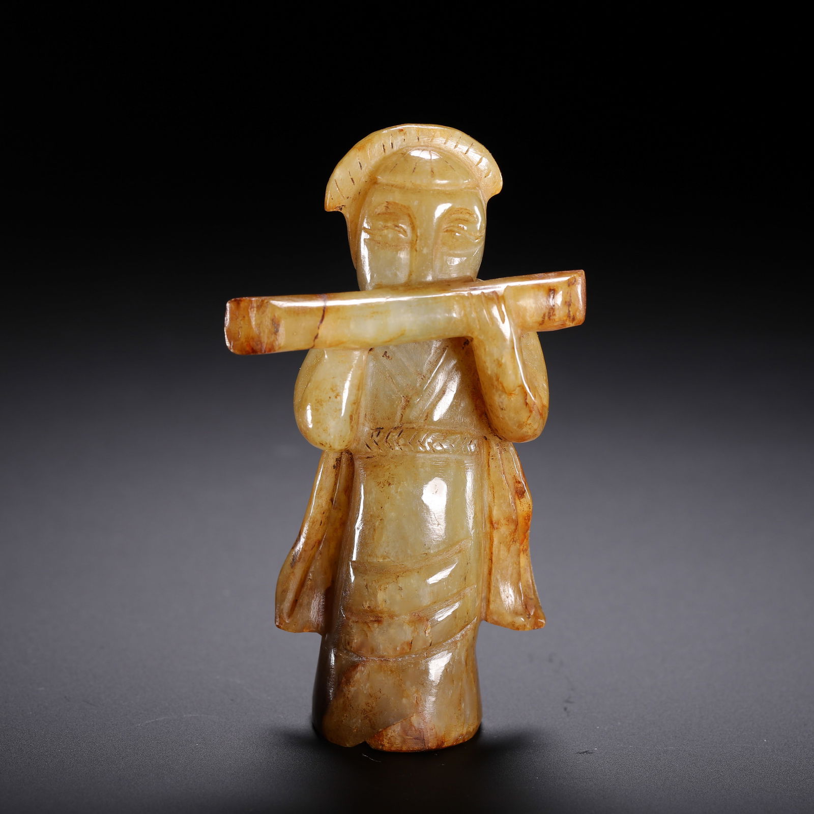 CHINESE ARCHAIC JADE MUSICIAN FIGURE: Dimensions: L. 5 cm. W. 2.5 cm. H. 8.5 cm. Weight 90 grams. This expressive Chinese archaic jade carving depicts a standing musician playing a flute, with simplified facial features, draped robes