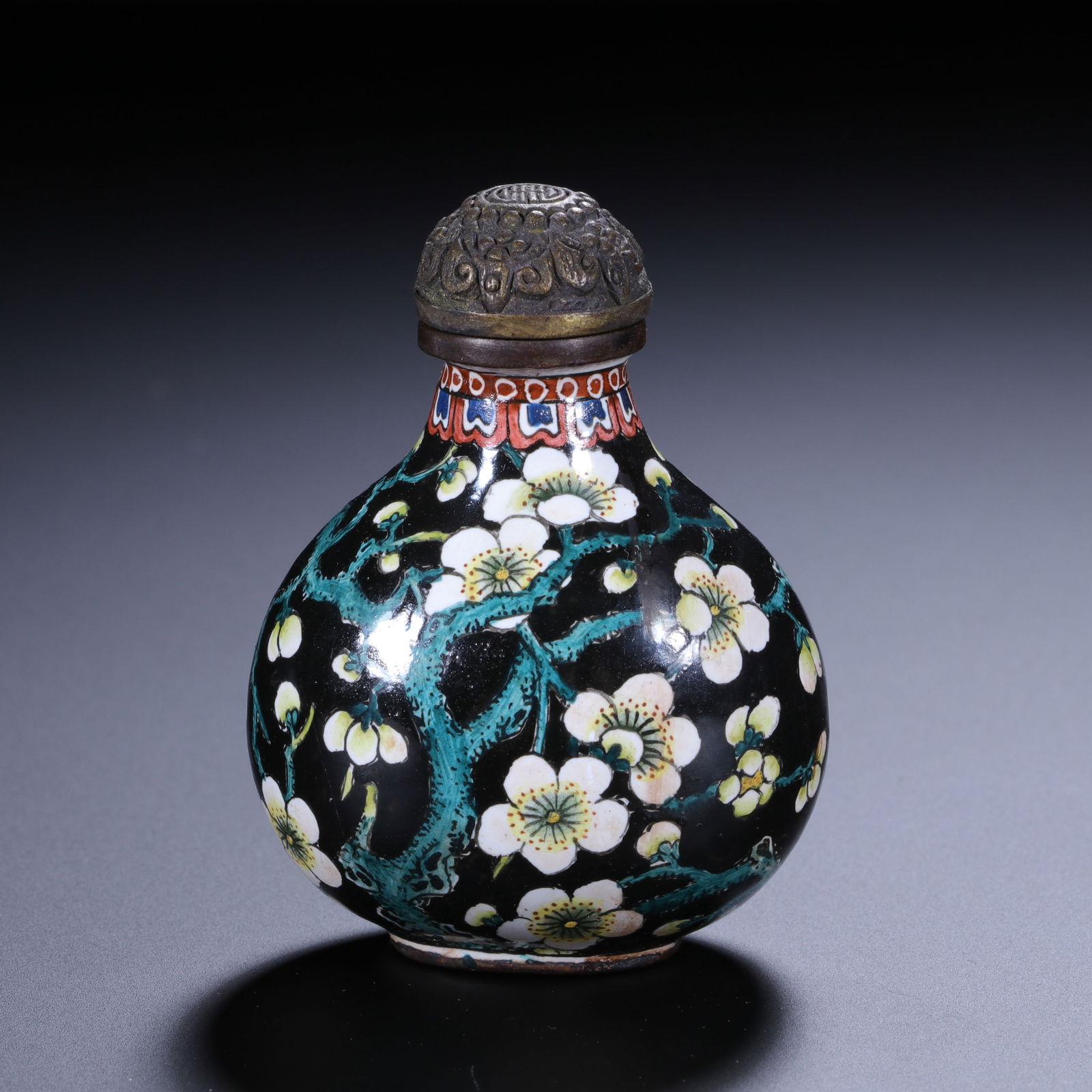 CHINESE ENAMELED COPPER SNUFF BOTTLE: Dimensions: H. 5.2 cm. W. 3.9 cm. This delicate Chinese enameled copper snuff bottle measures 5.2 cm in height and 3.9 cm in width, featuring a globular body with a rich black enamel ground.