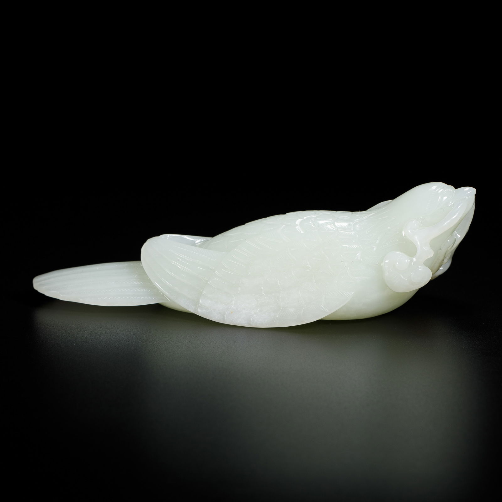 CHINESE HETIAN JADE BIRD TOGGLE: Dimensions: L. 13.8 cm. W. 5 cm. H. 4 cm. Weight 248 grams. This finely carved toggle is fashioned from translucent white Hetian jade, shaped into a lifelike bird with meticulously rendered