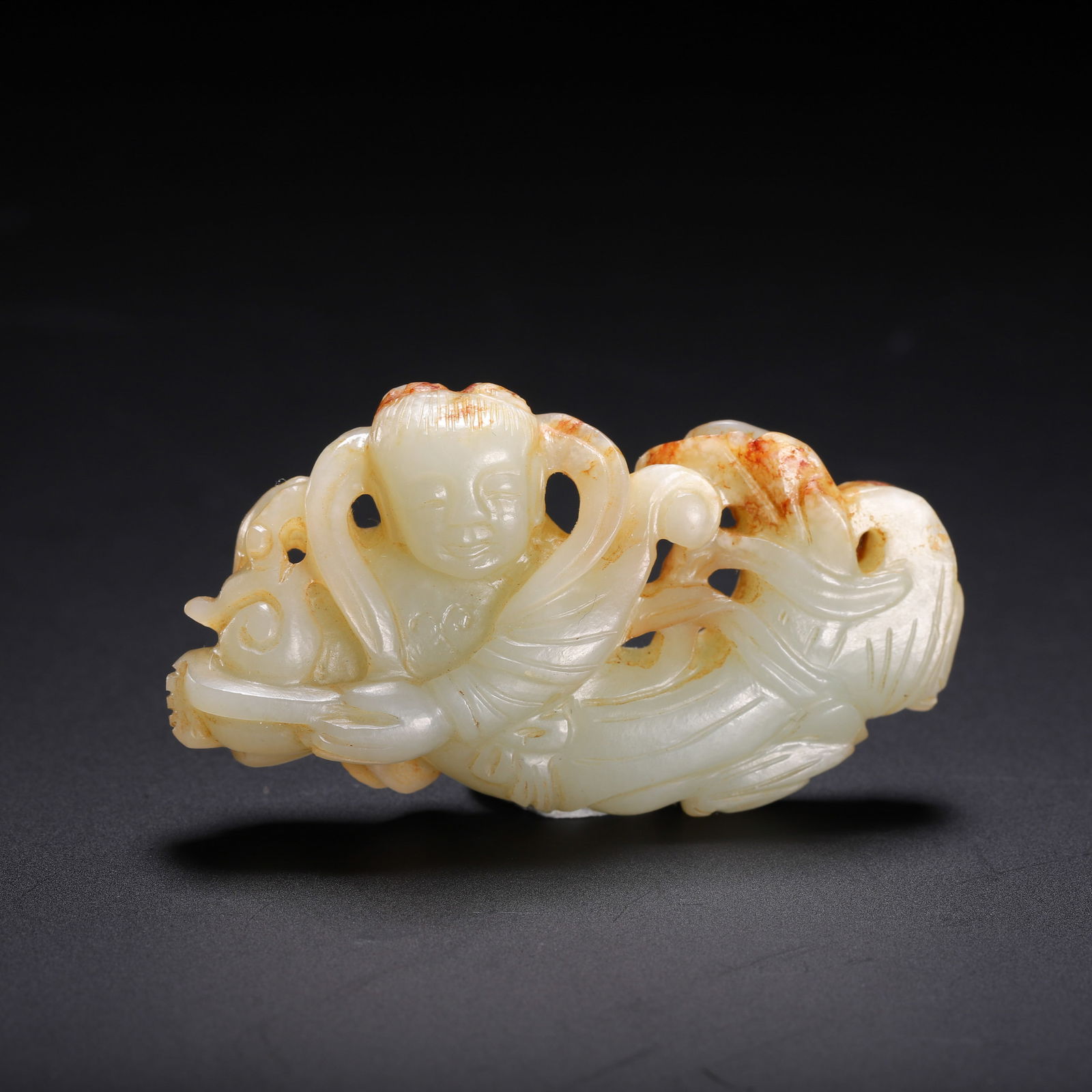 CHINESE HETIAN JADE BOY PENDANT: Dimensions: L. 5.5 cm. W. 3 cm. Weight 20 grams. This delicate Chinese Hetian white jade carving depicts a playful boy (tongzi) with flowing robes and reticulated cloud scrolls, accented with