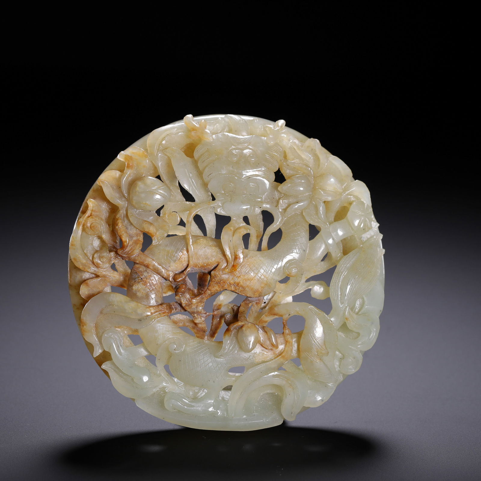 CHINESE JADE OPENWORK CIRCULAR PLAQUE: Dimensions: L. 9.6 cm. Weight 160 grams. This exquisite Chinese jade openwork circular plaque (wazi) features a dynamic composition of dragon and phoenix motifs, rendered through intricate