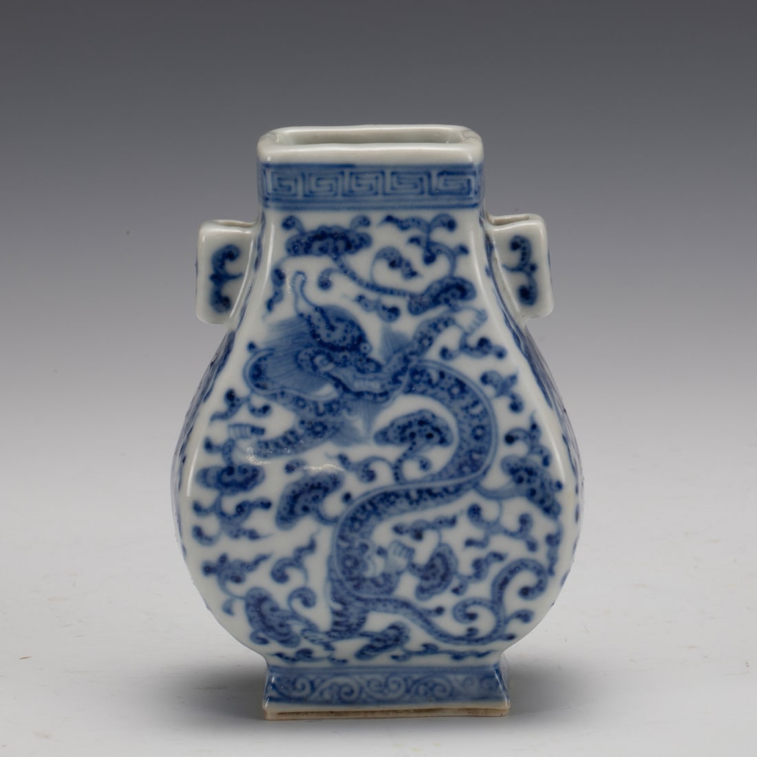 QING BLUE & WHITE DRAGON DOUBLE EAR ZUN: Measurements: Length: 7 cm, Width: 9.8 cm, Height: 5 cm Chinese Qing Dynasty Blue and White Dragon Porcelain Double Ear Zun Vase. This vase potted in a Zun shaped vase, thick and large, a drum abdomen