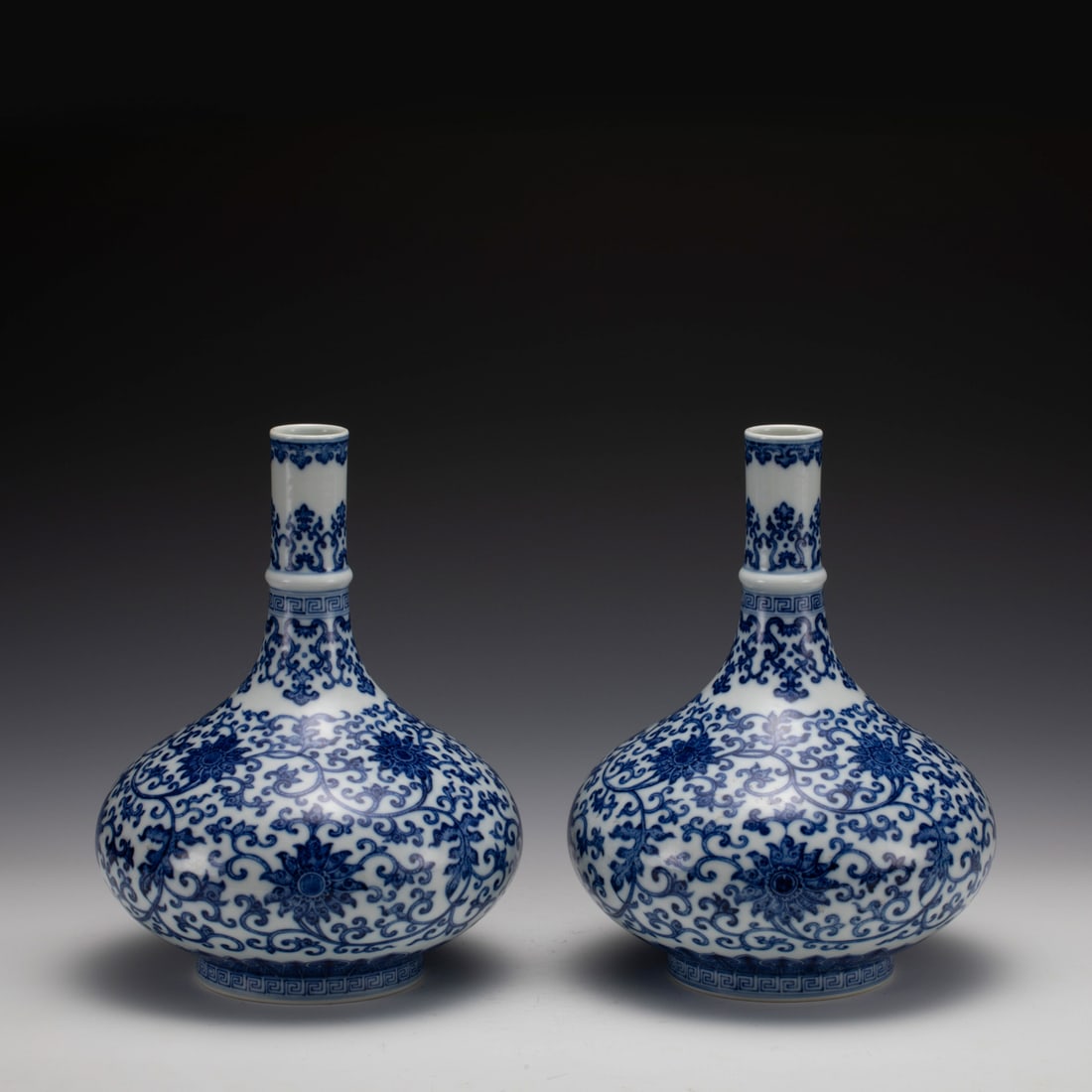 PAIR QING BLUE & WHITE LOTUS VASES: Measurements: Width: 21 cm, Height: 27.5 cm Pair of Qing Dynasty Blue and White Lotus Porcelain Bottle Vases. Potted in oval shape vase, heavy on mid body, round mouth rim with tall cylindrical